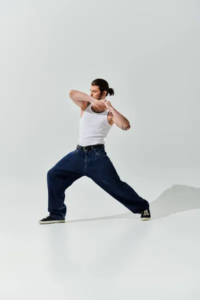 White tank top-clad man gracefully practicing yoga pose. — Stock Photo