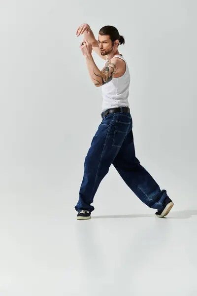 A caucasian man in a white tank top joyfully dances. — Stock Photo