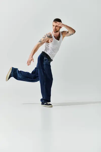 Handsome man in white tank top dancing energetically. — Stock Photo