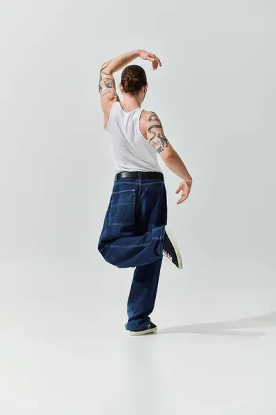 Schöner Mann in weißem Hemd und Jeans, der seine tänzerischen Fähigkeiten zeigt. — Stockfoto