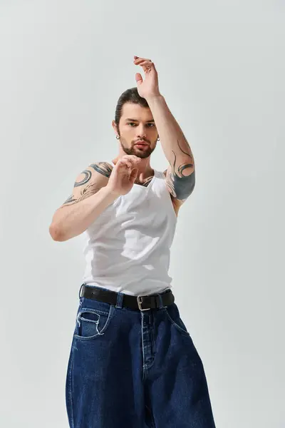 A handsome Caucasian man dressed in a trendy white shirt and blue jeans. — Stock Photo