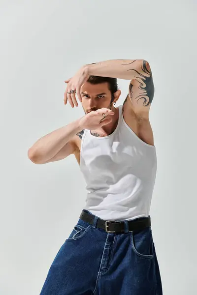 Hombre caucásico guapo con confianza vestido con una camiseta blanca y vaqueros azules. — Stock Photo