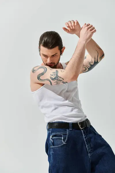 Bello uomo caucasico in abbigliamento alla moda in mostra un tatuaggio intricato sul braccio. — Foto stock