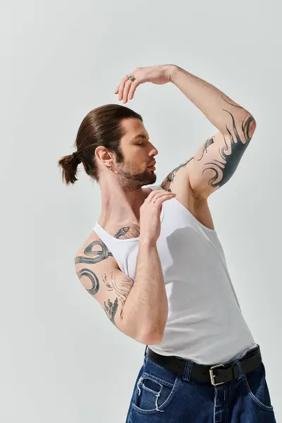 Handsome man with long hair and arm tattoos. — Stock Photo