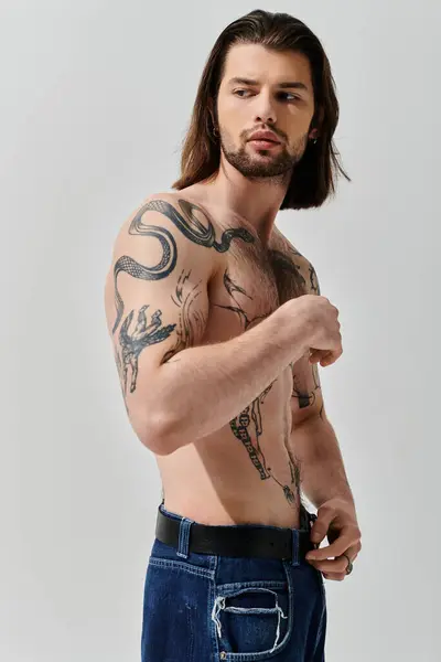 A handsome Caucasian man with long hair and chest tattoos. — Stock Photo