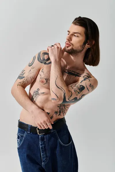 Stylish caucasian man with long hair and chest tattoos. — Stock Photo