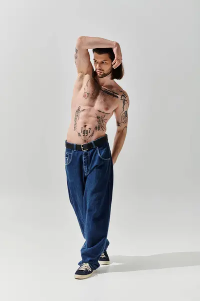 A shirtless man flaunts chest tattoos. — Stock Photo