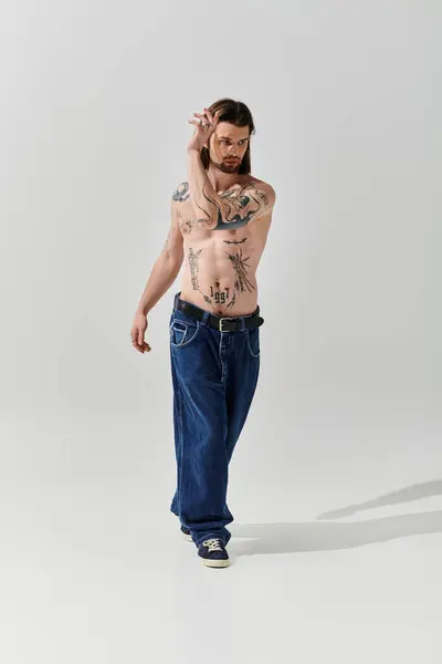 Handsome man with body tattoos walking in trendy attire. — Stock Photo
