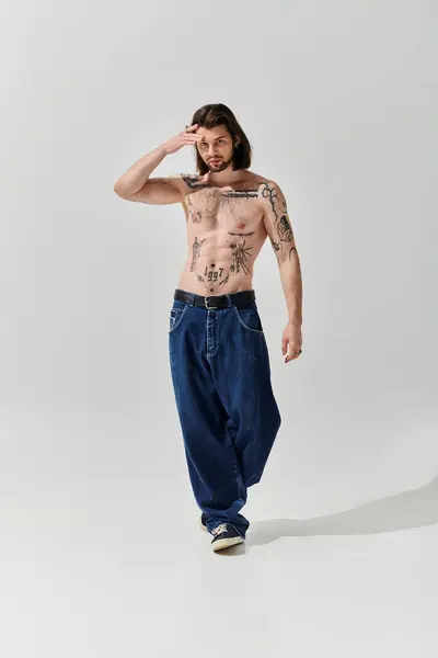 Shirtless man with chest tattoos exudes confidence and style. — Stock Photo
