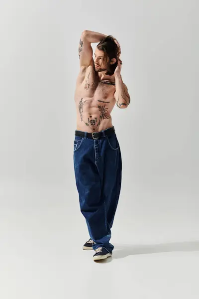 A handsome caucasian man displaying intricate tattoos on his chest and shirtless body. — Stock Photo