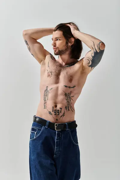 Un uomo senza maglietta rivela tatuaggi al petto intricati. — Foto stock