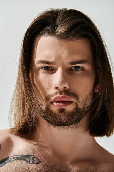 Schöner Mann mit langen Haaren und Bart, in trendiger Kleidung. — Stockfoto