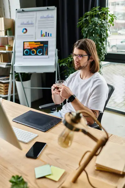 Un hombre absorto en su trabajo mientras está sentado en una mesa. — Stock Photo