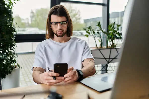 A Caucasian businessman working diligently while using a smartphone at his desk. — Stock Photo