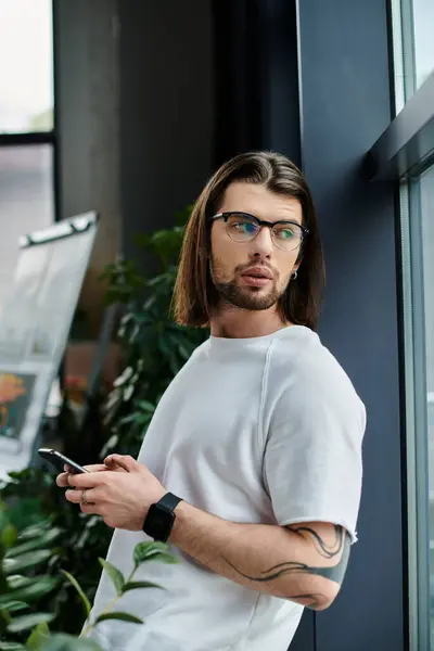Businessman with long hair and glasses using cell phone. — Stock Photo
