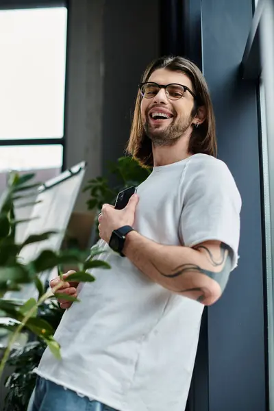 Caucasian businessman with long hair and glasses using smartphone. — Stock Photo