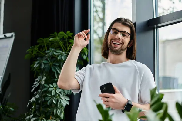 Ein gutaussehender kaukasischer Geschäftsmann in weißem Hemd mit einem Smartphone im Büro. — Stockfoto