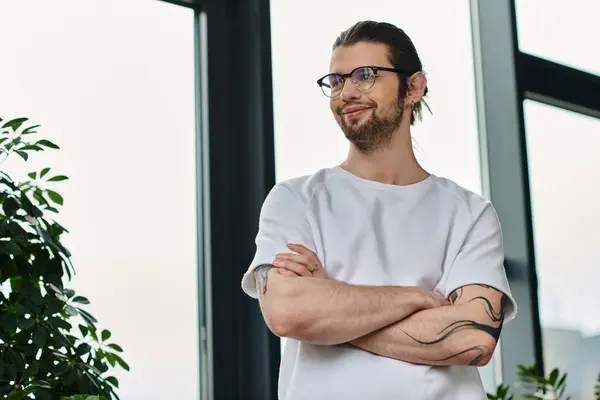 Handsome caucasian businessman with crossed arms standing in front of a window. — Stock Photo