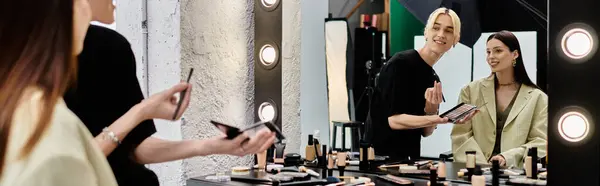 Estilista aplicando maquiagem para mulher jovem. — Fotografia de Stock