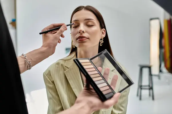 Makeup artist perfecting womans look. — Stock Photo