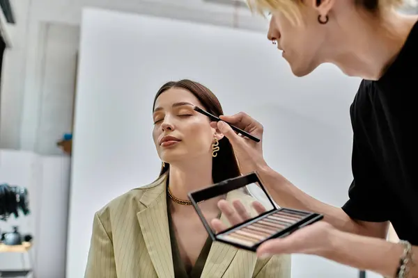 Truccatore professionista che applica il trucco per migliorare una bellezza naturale delle donne. — Foto stock