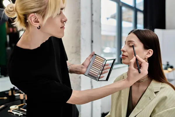 A professional makeup artist enhances a womans natural beauty. — Stock Photo