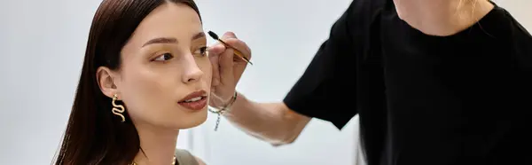 Female client enjoys makeup application by skilled artist. — Stock Photo