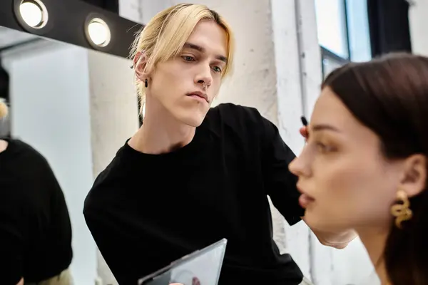 Morena mujer disfrutando de la sesión de maquillaje con estilista. - foto de stock