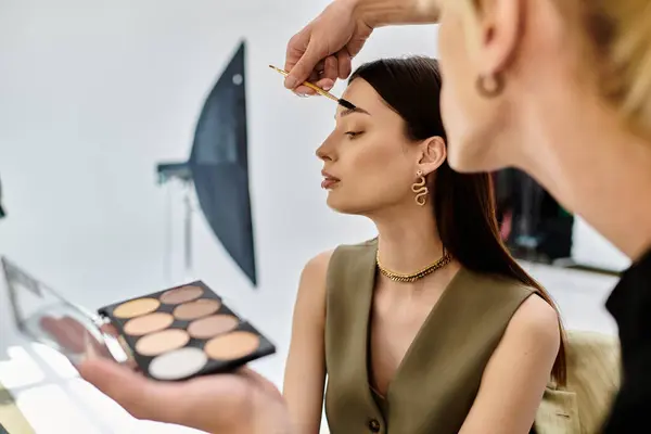 Un truccatore professionista che valorizza una bellezza femminile. — Foto stock