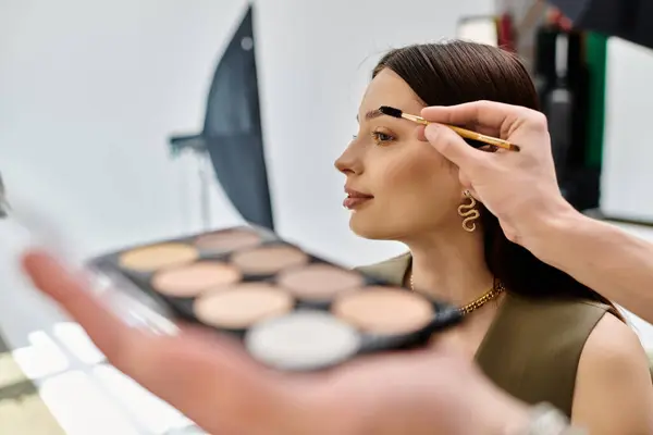 A woman receiving a makeup application from a talented artist. — Stock Photo