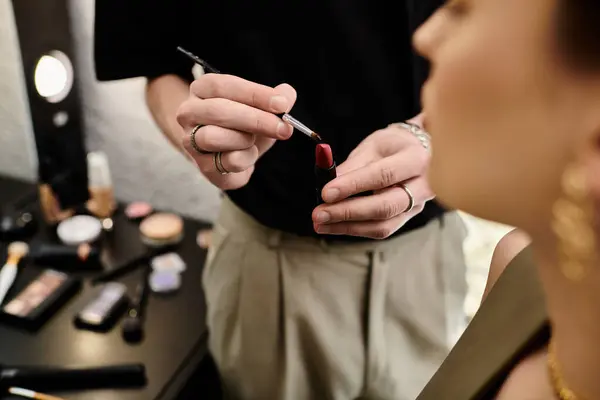 A woman receives makeup treatment from a male artist. — Stock Photo