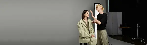Man applies makeup to womans face in front of mirror. — Stock Photo