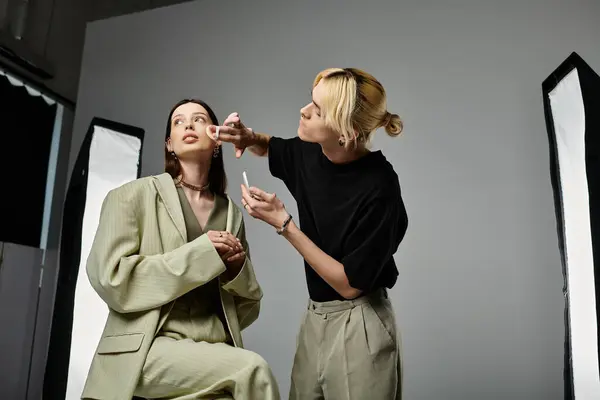 A makeup artist works on a womans face, enhancing her beauty with skillful artistry. — Stock Photo