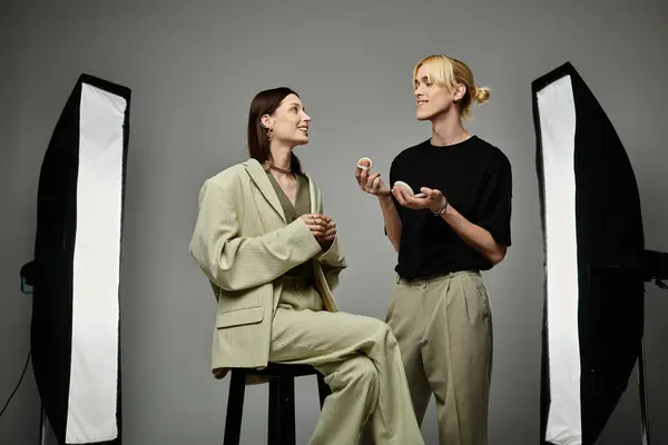 Un maquilleur applique du maquillage à une cliente dans un studio photo. — Photo de stock