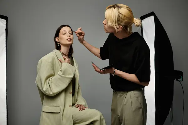 Expert makeup artist applying makeup to a womans face. — Stock Photo