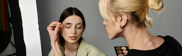 Un artista applica il trucco su un volto femminile. — Foto stock