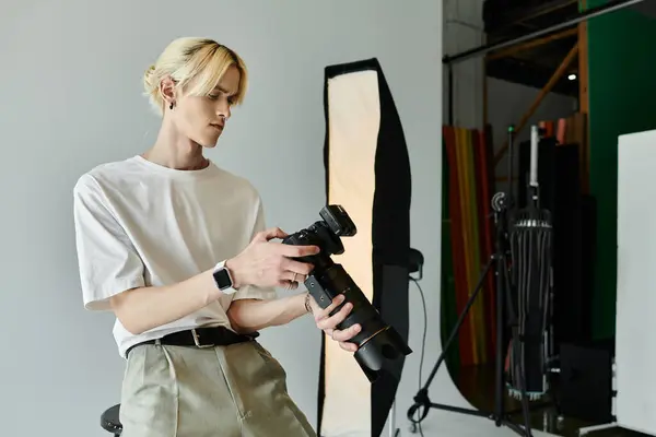 Man in white shirt holding camera. — Stock Photo