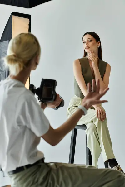 Mujer en taburete posa para fotógrafo. - foto de stock