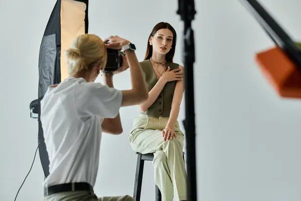 Talented man taking photos of young woman on camera. — Stock Photo
