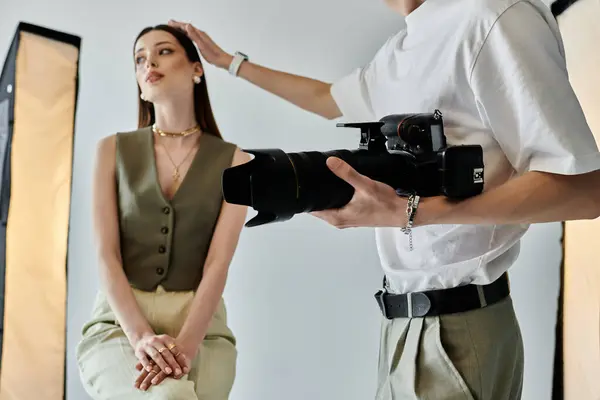 Woman poses on chair as man photographs her. — Stock Photo