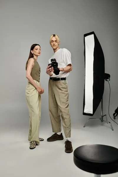 A man takes photos of a female model in a creative setting. — Stock Photo