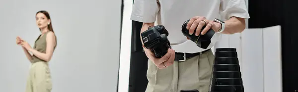 A man holds a camera in front of female model. — Stock Photo