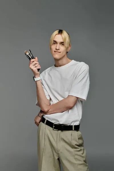 A focused young man holds brushes. — Stock Photo