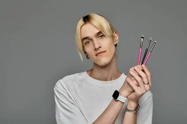 A man holds brushes in hand. — Stock Photo