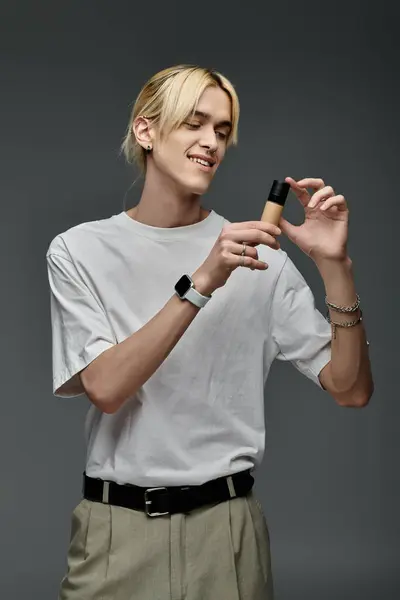 Happy blonde man holding highlighter and smiling on grey background — Stock Photo