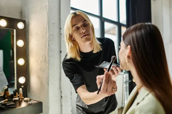 Appealing makeup artist transforms a womans look. — Stock Photo