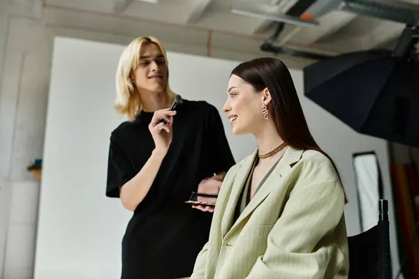 Good looking makeup artist transforms a womans look. — Stock Photo