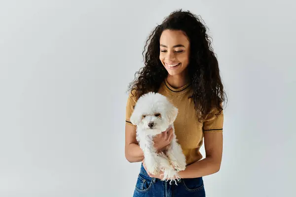 Woman lovingly cradles her white bichon frise in her hands. — Stock Photo