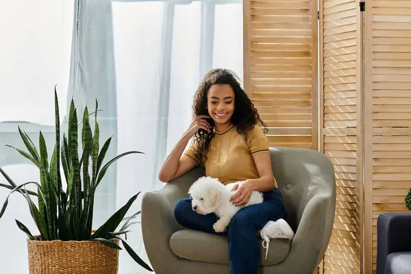Woman sitting with her bichon frise on her lap. — Stock Photo