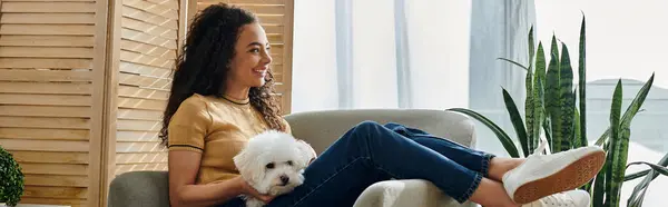 Woman sitting, cherishing her white dog in a chair. — Stock Photo